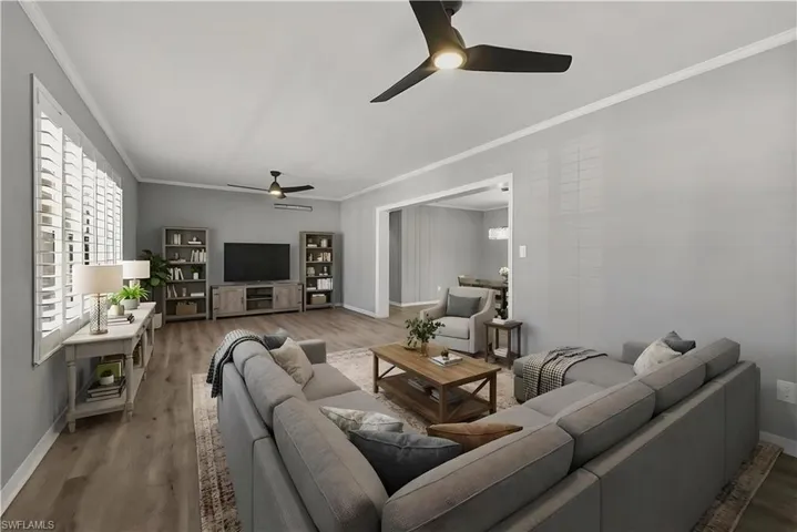 Virtually staged Living room with ceiling fan, wood finished floors, and ornamental molding