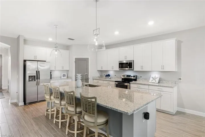 Kitchen featuring appliances with stainless steel finishes, light hardwood / wood-style floors, sink, and white cabinets