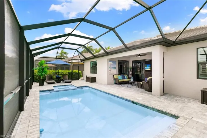 View of swimming pool featuring a patio, an outdoor living space, ceiling fan, and glass enclosure