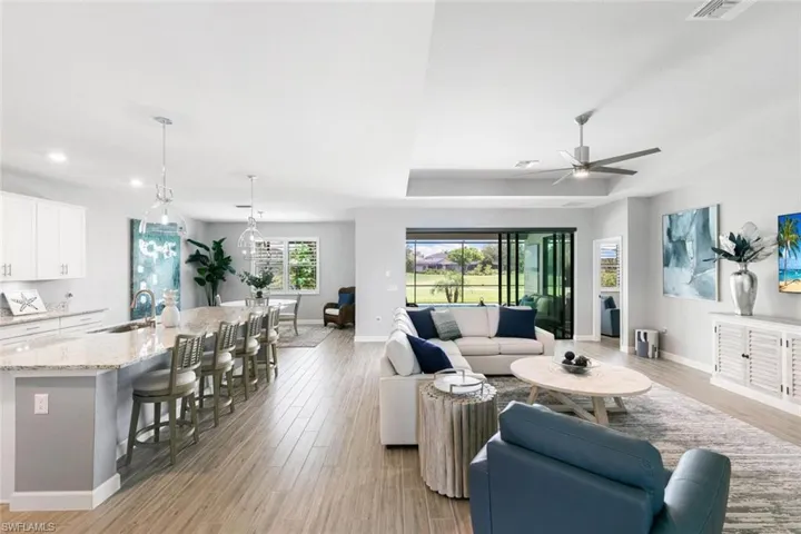 Living room featuring light hardwood / wood-style floors, ceiling fan, and sink