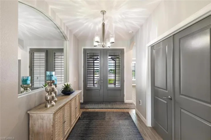 Foyer entrance with a notable chandelier and dark hardwood / wood-style floors