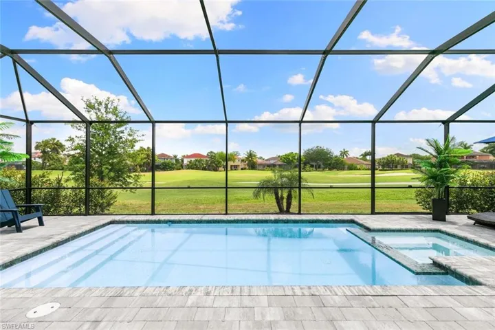 View of swimming pool featuring a patio, a yard, a lanai, and an in ground hot tub