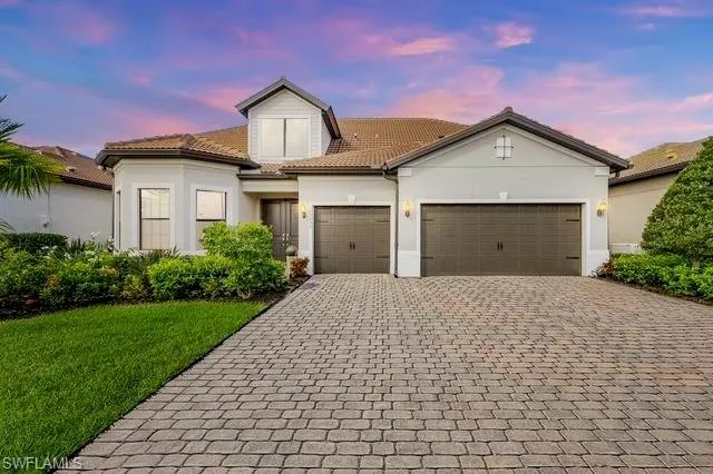 View of front of house featuring a lawn and a garage