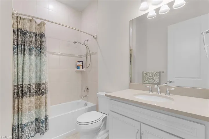 Full bathroom featuring vanity, toilet, and shower / bath combo with shower curtain
