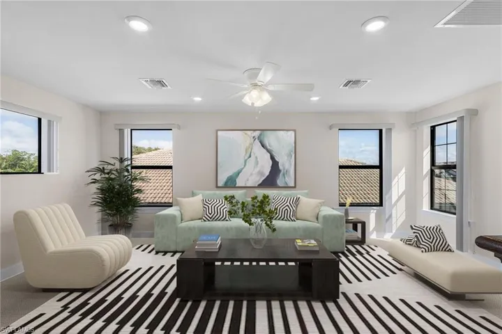 Carpeted living room featuring ceiling fan