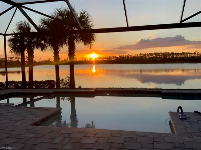 Dock area with a water view, glass enclosure, and a patio area