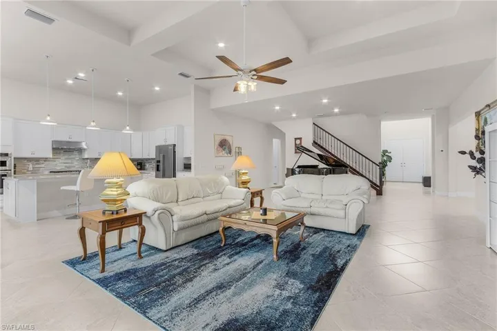 Tiled living room with ceiling fan and beam ceiling