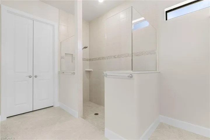 Bathroom with tile patterned flooring and tiled shower