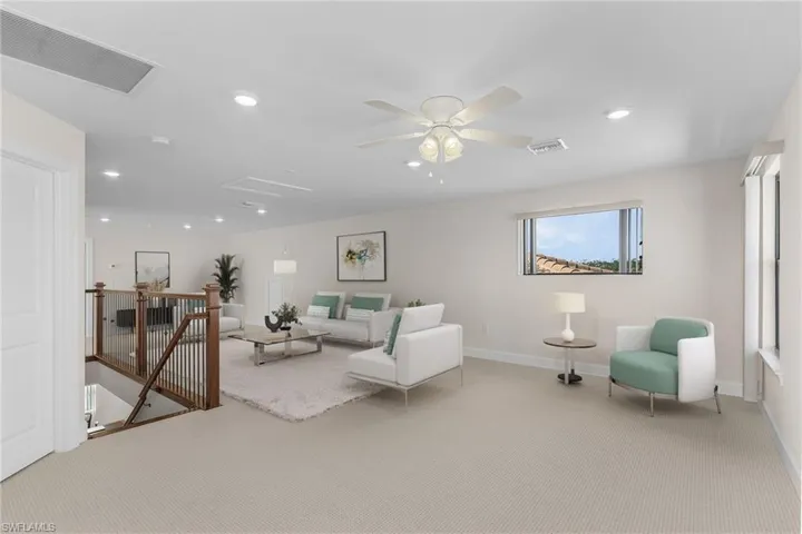 Carpeted living room featuring ceiling fan
