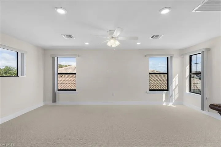 Unfurnished room with ceiling fan and light colored carpet