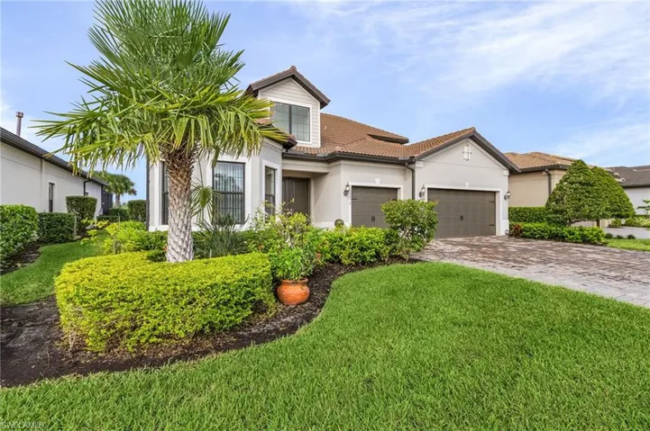 View of front of property featuring a front yard and a garage