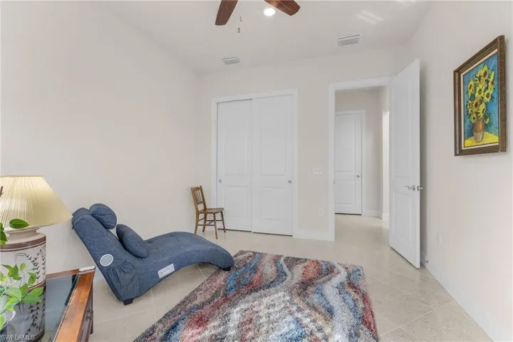 Sitting room featuring ceiling fan and light tile patterned floors