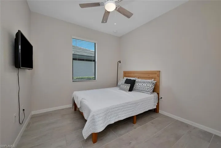 Bedroom with a ceiling fan and light tile patterned floors