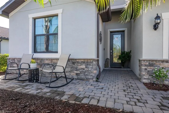 View of exterior entry featuring stone siding and stucco siding