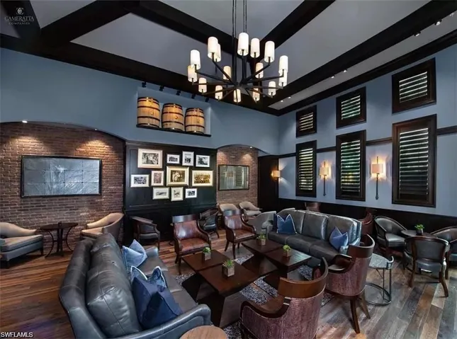 Cinema room with beamed ceiling, dark wood-type flooring, a towering ceiling, and a chandelier