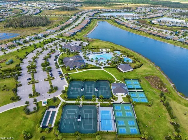 Aerial view of property and surrounding area featuring a nearby body of water and nearby suburban area