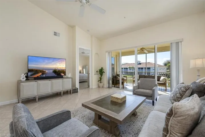 Living room with light tile patterned floors and high vaulted ceiling