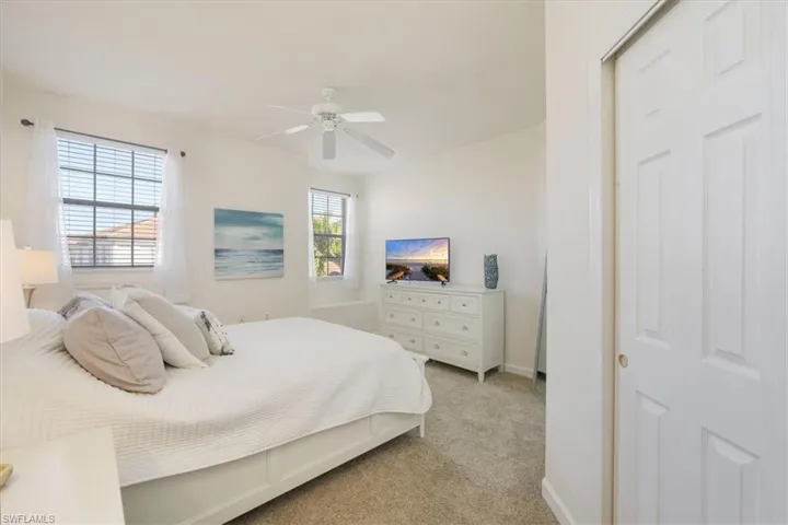 Bedroom featuring light carpet and a ceiling fan