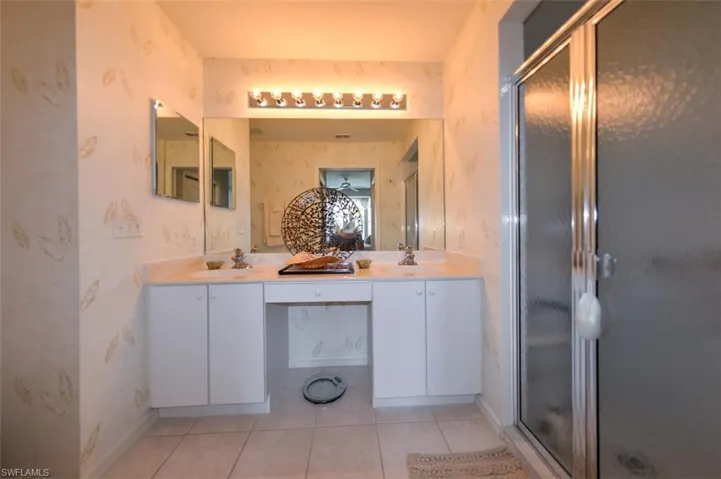 Bathroom featuring vanity, tile patterned floors, and an enclosed shower