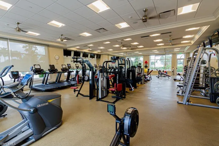 Gym with ornamental molding, a paneled ceiling, and ceiling fan