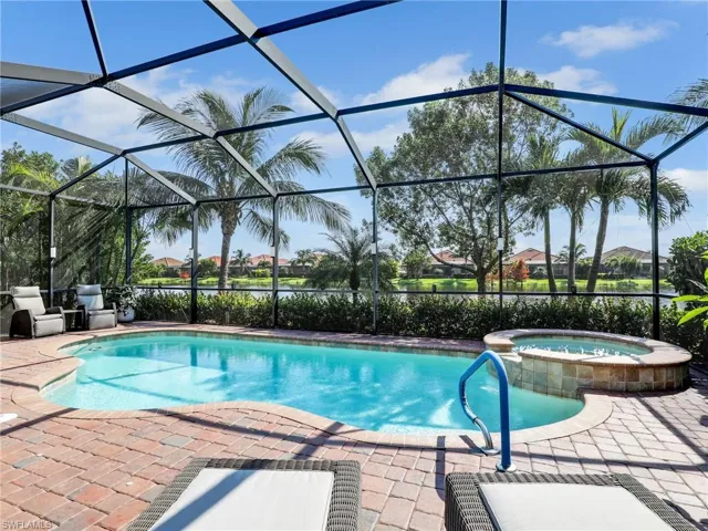 View of pool with a patio area, an in ground hot tub, and screened enclosure