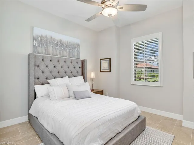 Bedroom with light tile patterned flooring and ceiling fan