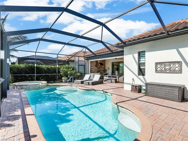 View of pool with an in ground hot tub, an outdoor hangout area, a lanai, a patio, and ceiling fan