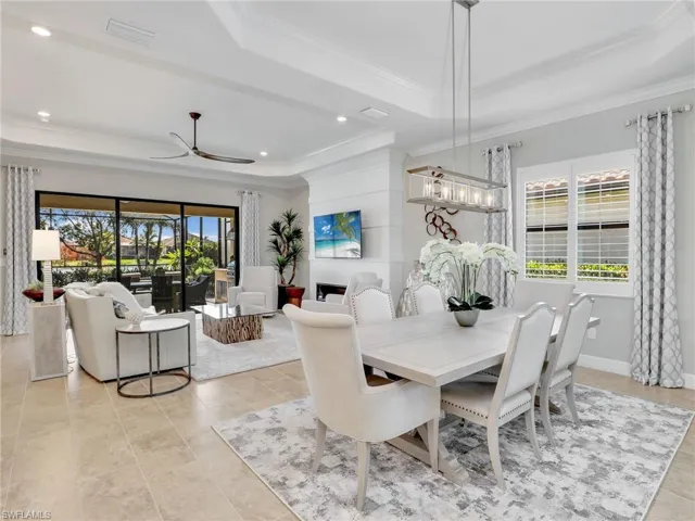 Dining area with ornamental molding, ceiling fan, plenty of natural light, and a raised ceiling