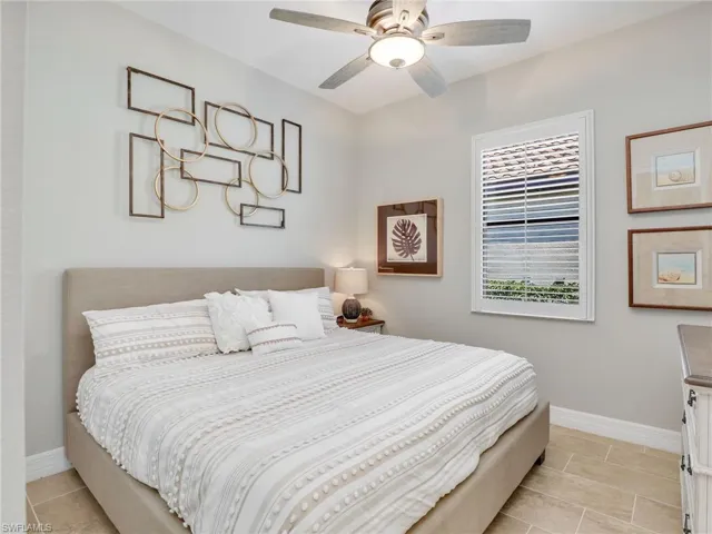 Bedroom with ceiling fan and light tile patterned floors
