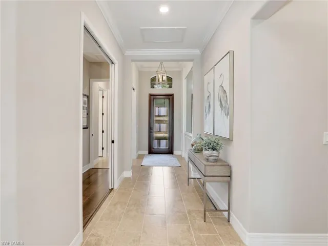 Foyer entrance with crown molding and light tile patterned floors