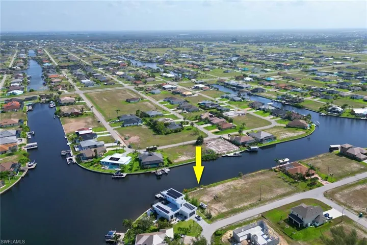 Aerial view of property and surrounding area with nearby suburban area and a nearby body of water