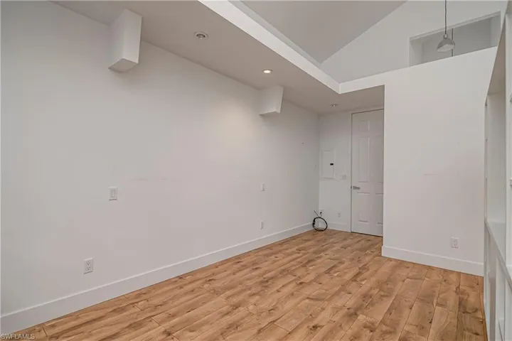 Spare room featuring light wood-style flooring, recessed lighting, and high vaulted ceiling