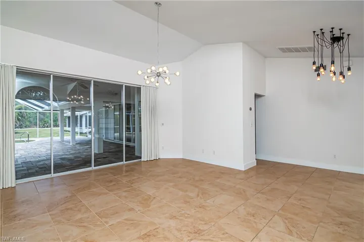 Unfurnished dining area with a chandelier, high vaulted ceiling, and a sunroom