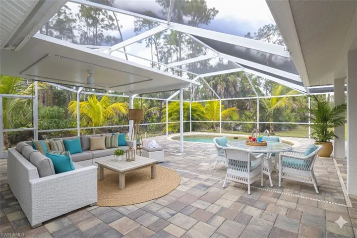 View of patio featuring a sunroom, a lanai, an outdoor pool, outdoor dining space, and an outdoor hangout area