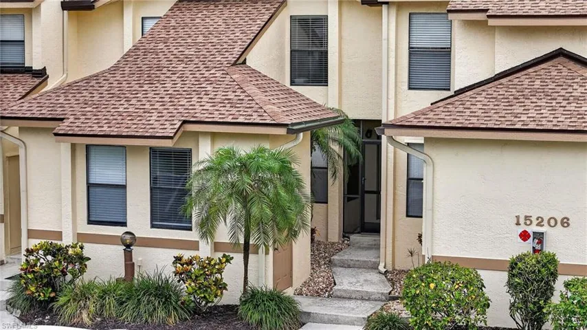 Stucco exterior with brown trim accents and a shingle roof