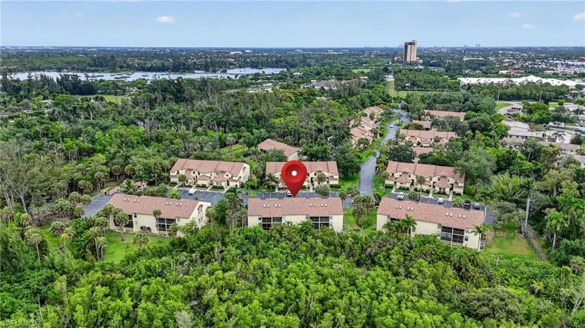 Aerial perspective showcasing a residential community surrounded by lush greenery