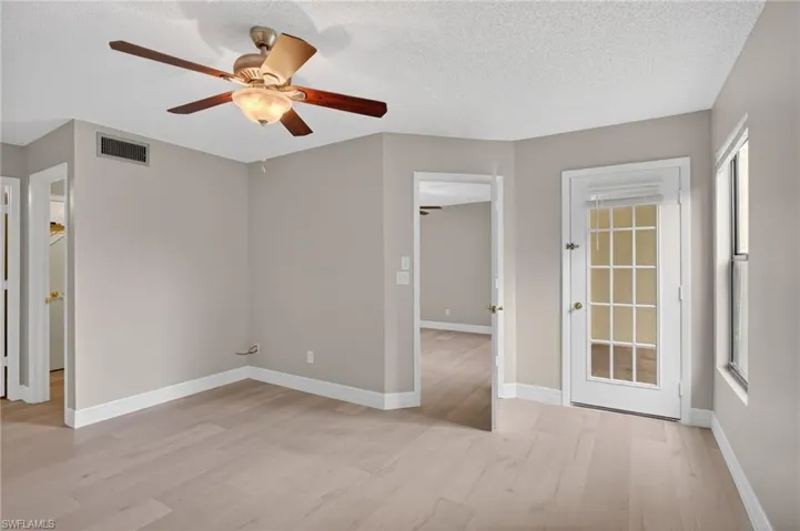 Room featuring light-toned wood-finish flooring, neutral wall paint, and white baseboards