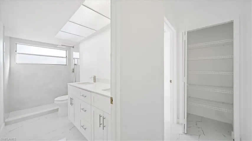 Bathroom with light marble finish flooring and double vanity
