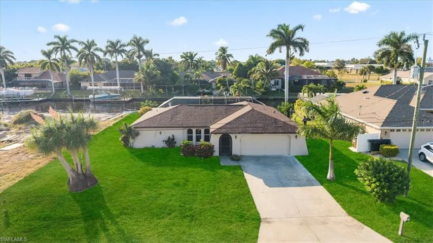 Ranch-style house with a water view, concrete driveway, a residential view, and a garage