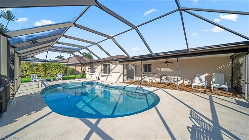 Swimming pool with a sunroom, glass enclosure, a patio area, and ceiling fan