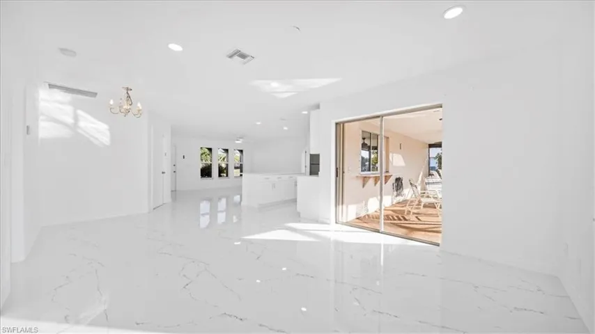 Spare room featuring light marble finish flooring, recessed lighting, and a chandelier