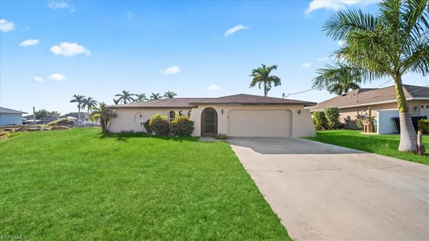 Single story home with stucco siding, concrete driveway, a front lawn, and a garage