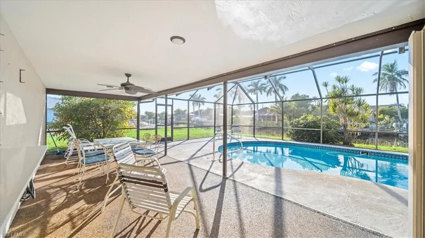 Swimming pool featuring a sunroom, a lanai, a patio, and ceiling fan