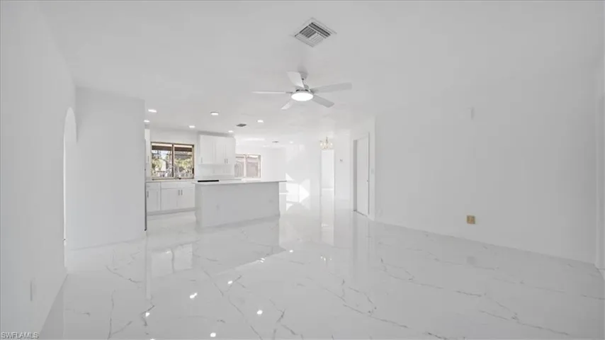 Unfurnished living room featuring light marble finish flooring, recessed lighting, and a ceiling fan