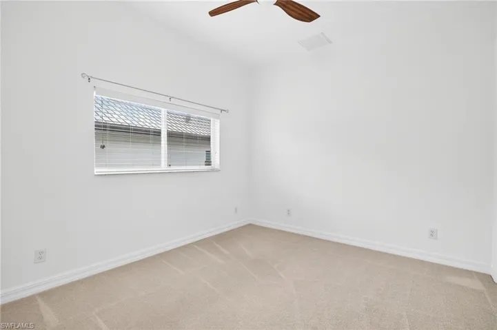 Spare room with light colored carpet and a ceiling fan