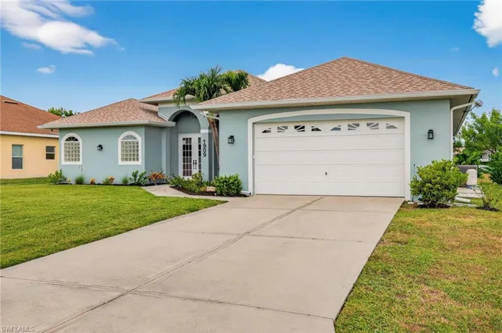 Ranch-style home featuring a front lawn, roof with shingles, stucco siding, concrete driveway, and an attached garage