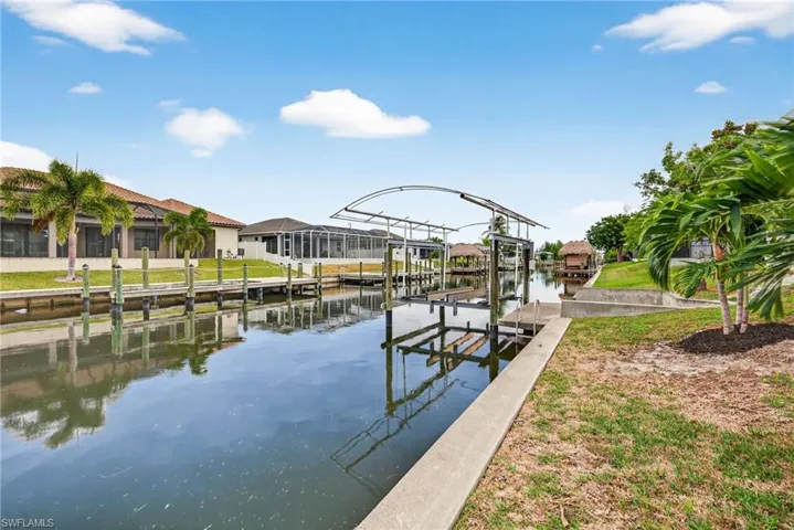 Dock featuring boat lift, a residential view, and a water view