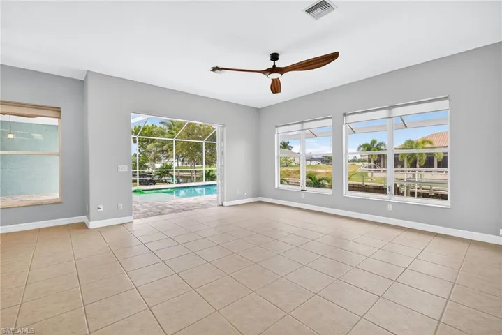 Empty room featuring a sunroom, light tile patterned flooring, healthy amount of natural light, and ceiling fan