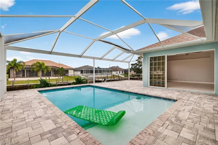 Outdoor pool featuring a patio, glass enclosure, and a sunroom