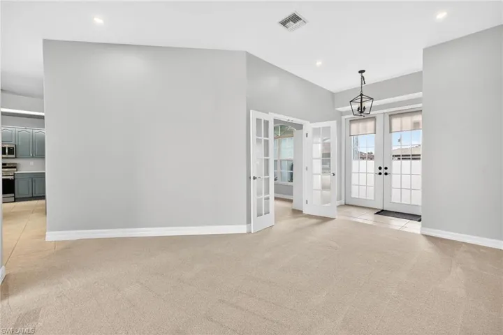 Foyer entrance featuring french doors, light colored carpet, and recessed lighting